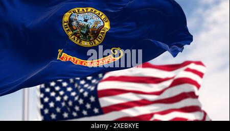 Die Flagge des Bundesstaates Idaho schwenkt zusammen mit der Nationalflagge der Vereinigten Staaten von Amerika an einem klaren Tag. Stockfoto