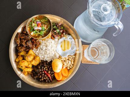 Newari Khaja Set typisch nepalesischer Thali mit Reisflocken, Choyila, Eiern, Kichererbsen, Tama, Bambussuppe, Mittagessen Aalu Sadheko Stockfoto