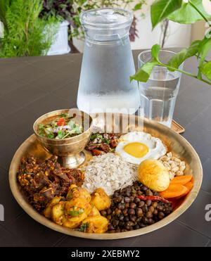 Newari Khaja Set typisch nepalesischer Thali mit Reisflocken, Choyila, Eiern, Kichererbsen, Tama, Bambussuppe, Mittagessen Aalu Sadheko Stockfoto