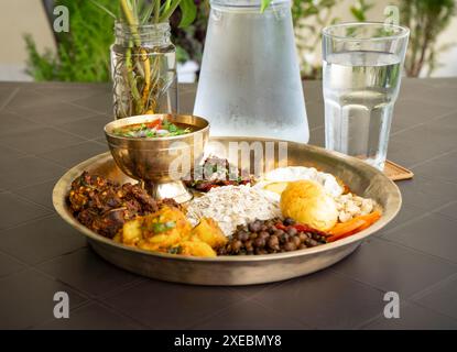 Newari Khaja Set typisch nepalesischer Thali mit Reisflocken, Choyila, Eiern, Kichererbsen, Tama, Bambussuppe, Mittagessen Aalu Sadheko Stockfoto