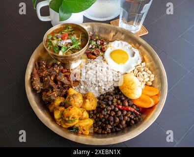 Newari Khaja Set typisch nepalesischer Thali mit Reisflocken, Choyila, Eiern, Kichererbsen, Tama, Bambussuppe, Mittagessen Aalu Sadheko Stockfoto