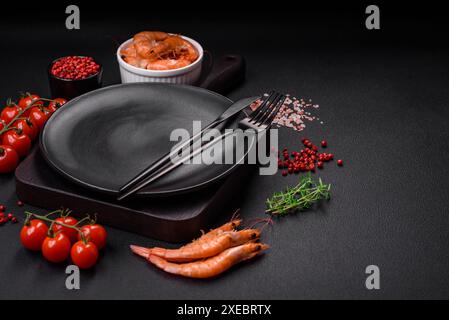 Zutaten zum Kochen von Kirschtomaten, Garnelen, Salz und Gewürzen Stockfoto