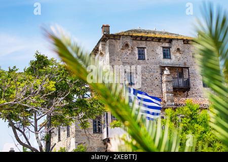 Ouranoupolis Turm auf der Halbinsel Athos auf Chalkidiki, Flagge Griechenlands durch die Palmblätter Stockfoto