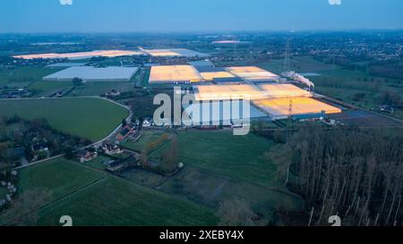 Duffel, Belgien, 20. März 2024, Twilight Glow over Industrial Gewächshäuser in Rural Landscape Stockfoto