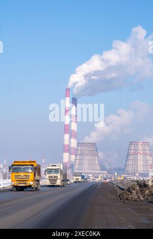 Der Himmel ist voller Rauch aus Fabrikschornsteinen in der Nähe von Automobilgebäuden Stockfoto