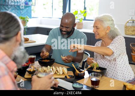 Zusammen essen, verschiedene Seniorenfreunde essen zu Hause Stockfoto