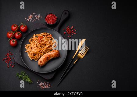 Köstliche saftige gegrillte Wurst mit Pasta oder Nudeln mit Salz, Gewürzen und Kräutern Stockfoto