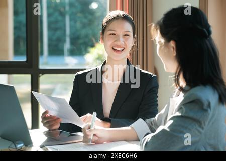 Zwei Frauen in Business-Anzügen reden miteinander Stockfoto