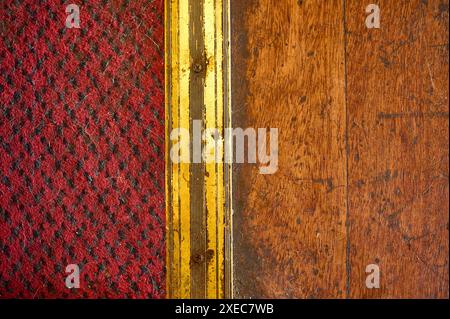 Metallstreifen, der Teppich vom Holzboden trennt Stockfoto
