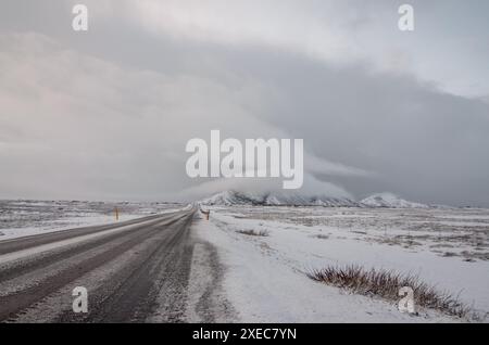 Das Winterwetter liegt vor Ihnen auf der Route 1 entlang Islands südlichem Rand auf dem Weg nach Vik und zum schwarzen Sandstrand Vikurfjara. Eine offene, wilde Straße. Stockfoto