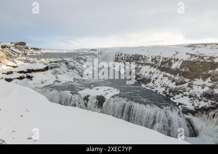 Die majestätischen Gullfoss-Wasserfälle dampfen über isländischen Felsen im Land des Feuers und des Eises an diesem hellen Wintertag auf dem goldenen Kreis. Stockfoto