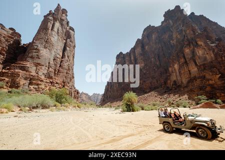 Touristen genießen eine Fahrt in einem Geländewagen, während sie einen abgelegenen Wüstenschlucht, Wadi Al Disah, Saudi, Arabien erkunden Stockfoto