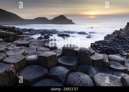 Sonnenuntergang über dem Giant's Causeway an der Causeway Coast, Bushmills, County Antrim, Nordirland. Frühjahr (März) 2024. Stockfoto