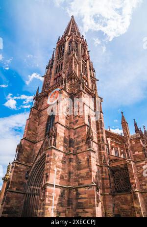 Deutschland, Freiburg im Breisgau, wunderschönes majestätisches münsterer Kirchturm mit Uhr in der Altstadt mit blauem Himmel Stockfoto