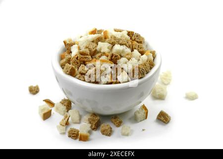 Brotcroutons auf weißem Hintergrund. Verstreuter Stapel hausgemachter Roggenbrotcroutons, isoliert auf weißem Hintergrund. Knusprige Brotwürfel, trockene Roggenbrösel. Stockfoto