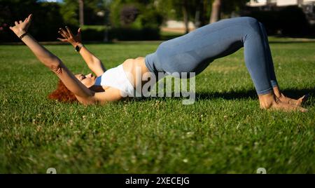 Frau, die hypopressive Übungen für den Beckenboden in einem Park macht Stockfoto