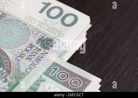 Banknoten gleichmäßig verteilt auf einem dunkelbraunen Schreibtisch, einsatzbereit. Stockfoto