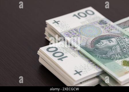 Banknoten gleichmäßig verteilt auf einem dunkelbraunen Schreibtisch, einsatzbereit. Stockfoto