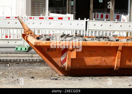 Container, orangefarbener Überwurf für Bauabfälle auf der Straße, Straßenbauarbeiten, Baustelle, Deutschland Stockfoto