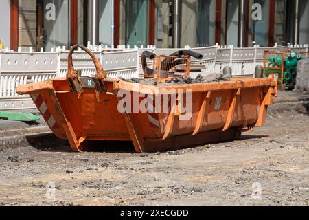 Container, orangefarbener Überwurf für Bauabfälle auf der Straße, Straßenbauarbeiten, Baustelle, Deutschland Stockfoto