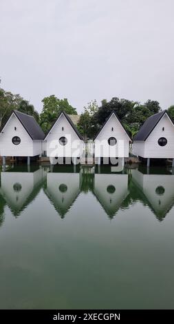Ein ruhiger See spiegelt eine Reihe von bezaubernden weißen Häusern wider, die eine malerische Szene der Ruhe und Schönheit schaffen Stockfoto