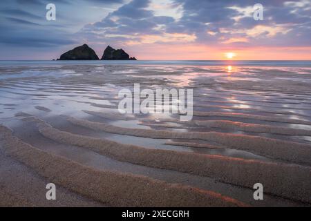 Sommersonnenuntergang über Holywell Bay Beach in der Nähe von Newquay, Cornwall, England. Sommer (Juni) 2024. Stockfoto