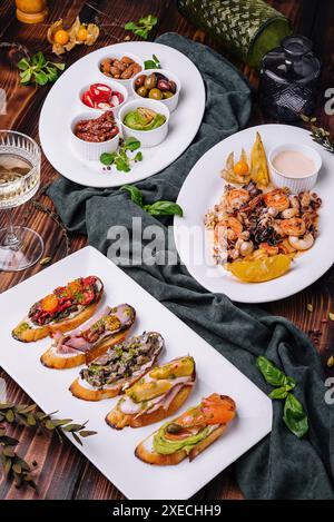 Bruschetta mit verschiedenen Füllungen mit einem Teller Meeresfrüchte Stockfoto