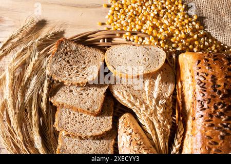 Der Ladentisch ist mit verschiedenen Arten von Weizen und Roggenbrot und Ohren von reifem Roggen und Weizen dekoriert. Dünne Brotscheiben. Stockfoto