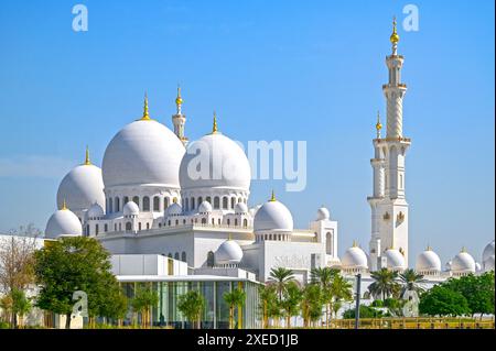 Kuppeln der Scheich-Zayed-Moschee vor blauem Himmel während des sonnigen Tages in Abu Dhabi in den Vereinigten Arabischen Emiraten Stockfoto