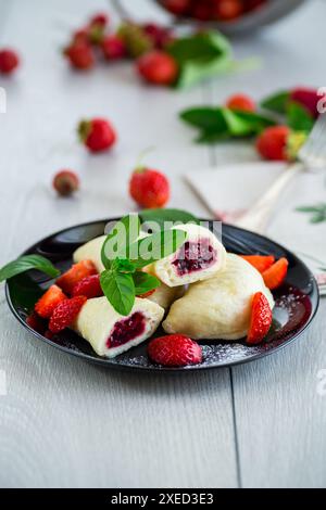 Gekochte süße, hausgemachte, gedämpfte Teigtaschen mit Erdbeeren. Stockfoto