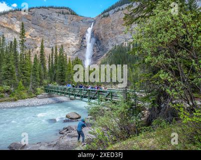 Yoho National Park, British Columbia, Kanada – 23. Juni 2024: Ein Mann fotografiert Touristen auf einer Fußgängerbrücke über den Yoho River an den Takakkaw Falls Stockfoto