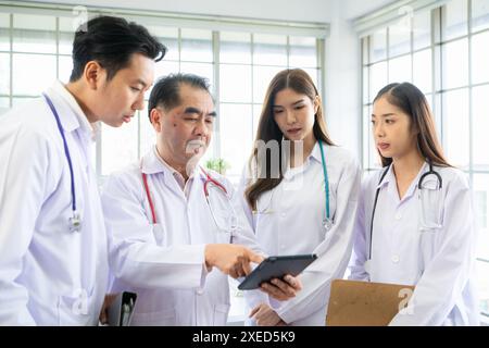 Ein Medizinstudent und ein Medizinstudent diskutieren eine Fallstudie zur Krankheitstherapie für einen Krankenhauspatienten. Stockfoto