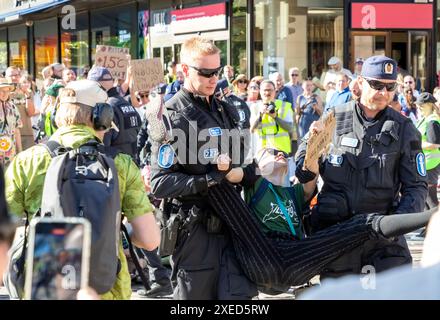 Die Polizei zwangsweise die Teilnehmer des Protestes der „Sturmwarnung“ der Extinction Rebellion Finland in Helsinki abschiebt. Stockfoto