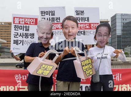 Mitglieder der südkoreanischen Bürgergruppe Gyeorehana (Bewegung für ein Korea), die Masken des südkoreanischen Präsidenten Yoon Suk Yeol (C) tragen, US-Präsident Joe Biden (L) und Japans Premierminister Fumio Kishida (R) treten mit Pappausschnitten auf, die Vorhängeschlösser mit der Aufschrift "war Alliance" zeigen, während eines Protests gegen eine trilaterale militärische Übung namens "Freedom Edge" vor der US-Botschaft in Seoul. Südkorea, die USA und Japan starteten am 27. Juni große neue militärische Übungen, so Südkoreas Joint Chiefs of Staff, als die Verbündeten versuchen, der wachsenden Bedrohung durch Nordkorea entgegenzuwirken. Südkoreanische Bürgergruppe Gyeo Stockfoto