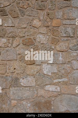 Hellbraune Steinmauer in Panorama-Nahaufnahme aus alten, grob behauenen, verschiedenen Natursteinen 1 Stockfoto