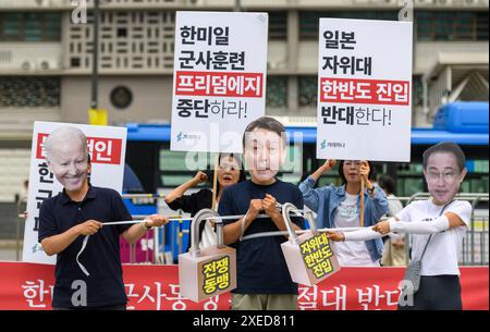 Mitglieder der südkoreanischen Bürgergruppe Gyeorehana (Bewegung für ein Korea), die Masken des südkoreanischen Präsidenten Yoon Suk Yeol (C) tragen, US-Präsident Joe Biden (L) und Japans Premierminister Fumio Kishida (R) treten mit Pappausschnitten auf, die Vorhängeschlösser mit der Aufschrift "war Alliance" zeigen, während eines Protests gegen eine trilaterale militärische Übung namens "Freedom Edge" vor der US-Botschaft in Seoul. Südkorea, die USA und Japan starteten am 27. Juni große neue militärische Übungen, so Südkoreas Joint Chiefs of Staff, als die Verbündeten versuchen, der wachsenden Bedrohung durch Nordkorea entgegenzuwirken. Südkoreanische Bürgergruppe Gyeo Stockfoto