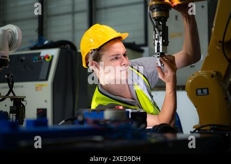 Techniker, der einen kleinen Roboterarm instand hält der Betrieb eines kleinen Roboterarms, der in der Industrie verwendet wird, wird repariert. Stockfoto