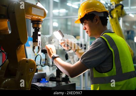 Techniker, der einen kleinen Roboterarm instand hält der Betrieb eines kleinen Roboterarms, der in der Industrie verwendet wird, wird repariert. Stockfoto