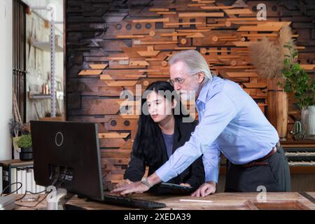 Geschäftsmänner und Geschäftsfrauen, die in einem modernen Bürozimmer am Computer arbeiten Stockfoto