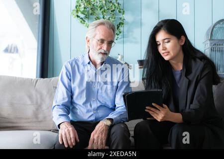 Leitende Angestellte und Versicherungsvertreter, die detaillierte Informationen über die Versicherungspolice für ältere Menschen bereitstellen. Stockfoto