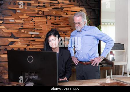 Geschäftsmänner und Geschäftsfrauen, die in einem modernen Bürozimmer am Computer arbeiten Stockfoto