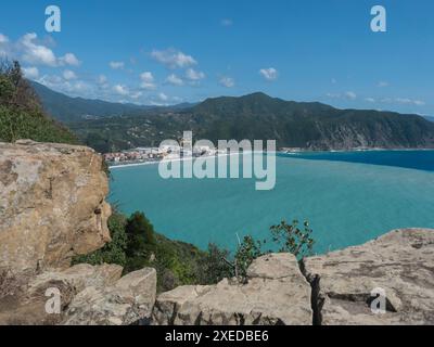 Panoramablick auf das Dorf Riva Trigoso von Torre Saracena in Punta Manara mit Felsen, Häusern, Werft und zweifarbigem Meer, Sestri Levante, Li Stockfoto