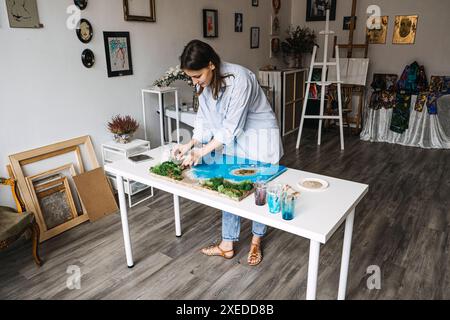 Eine Künstlerin, die in ihrem Studio eine Epoxidharzlandschaft herstellt Stockfoto