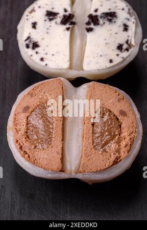 Köstliches süßes Mochi-Dessert mit Toppings auf dunklem Betonhintergrund Stockfoto