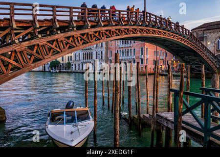 Die Accademia-Brücke (Ponte dell'Accademia) über den Canal Grande in Venedig, Italien. Pier mit Holzpfosten für Gondeln und Boote. Stockfoto