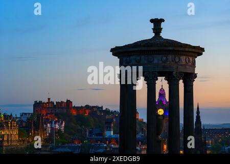 Dugald Stewart Monument, das das Balmoral Hotel umrahmt und Edinburgh Castle in der Abenddämmerung in der Stadt Edinburgh in Schottland, Großbritannien. Stockfoto