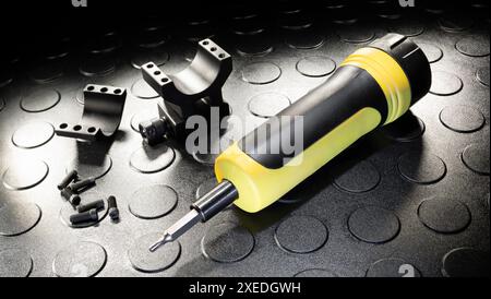 Handbetätigter Drehmomentschrauber, der in Zoll Pfund neben der Basis und den Ringen misst, mit denen eine Gewehroptik an einer Pistole befestigt wird. Stockfoto