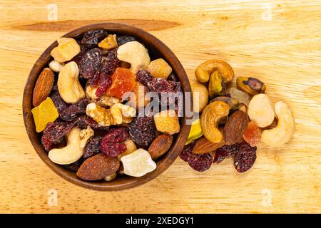Blick von oben auf verschiedene getrocknete gemischte Früchte und Nüsse in einer Holzschale. Stockfoto