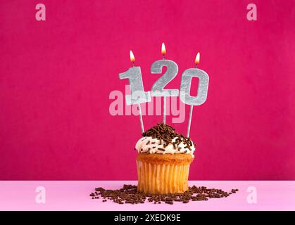 Geburtstagsfeier mit Kerze Nummer 120 - Schokoladen-Cupcake auf rosa Hintergrund Stockfoto
