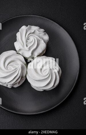 Köstlicher süßer Marshmallow auf dunklem Betonhintergrund Stockfoto